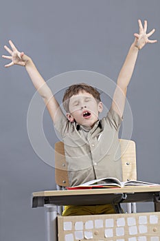 The child yawns in the classroom.