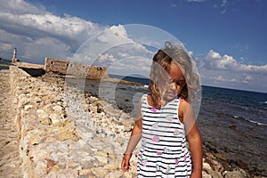 Child of 3-4 years in Chania, Crete with the background of the walls of the Venetian harbor photo