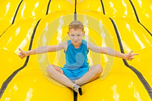 Child on yellow playground trampoline. Kids jump in inflatable bounce castle on kindergarten birthday party. Activity and play cen