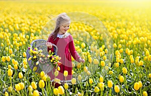 Child in yellow tulip flower field in Holland