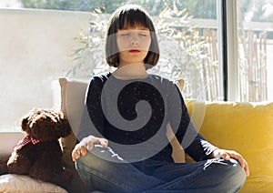 Child yoga at home - kid breathing for mindfulness while lockdown photo