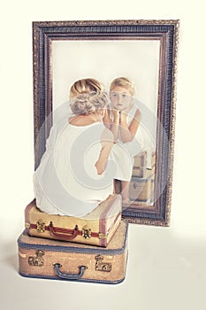 Child or young girl staring at herself in a mirror
