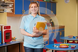 Childcare Worker Standing In Nursery