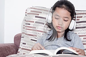 Childern reading a book on the sofa