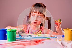 Childhood and art concept. Beautifuul girl painting with colour hands