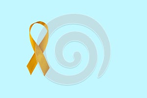 Childhood Cancer Awareness Yellow Ribbon on blue background with copy space photo