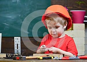 Childhood concept. Boy play as builder or repairer, work with tools. Child dreaming about future career in architecture