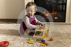 childhood, development, skills, motility games - little authentic child baby toddler girl composes sorts colored shapes