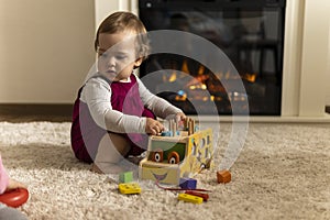 childhood, development, skills, motility games - little authentic child baby toddler girl composes sorts colored shapes