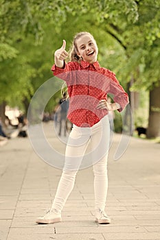 Childhood is exceptionally wonderful. Adorable small child gesturing thumbs up for playing outdoor. Childhood activity