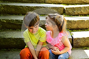 Childhood first love. summer holiday vacation. small girl and boy on stair. Relations. couple of little children. Boy