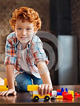 Beautiful blue eyed boy looking into camera while playing
