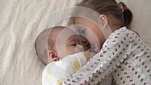 Childhood, infancy, family, sleep, rest concept - close up of two joyful happy children, newborn baby and 3-4 year old