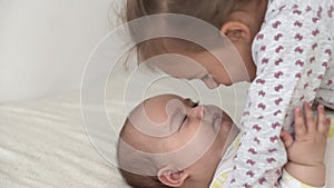 Childhood, infancy, family, sleep, rest concept - close up of two joyful happy children, newborn baby and 3-4 year old