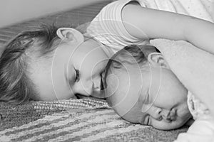 Childhood, infancy, family, sleep, rest, love concept - black white close up of two children, newborn baby and girl