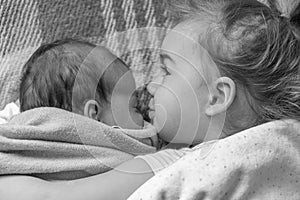 Childhood, infancy, family, sleep, rest, love concept - black white close up of two children, newborn baby and girl