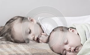 Childhood, infancy, family, sleep, rest, love concept - black white close up two children, newborn baby and girl