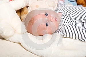 Childhood and innocence concept. Baby lying on white duvet