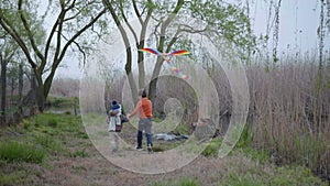 Childhood, joyful children brothers run holding hands playing with a kite in open air