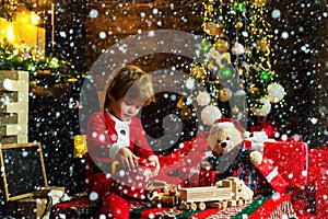 Childhood memories. Kid in snow. Santa boy celebrate christmas at home. Boy child play near christmas tree. Merry and