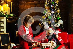 Childhood moments. Cute little santa baby with New years gifts on Christmassy background. Happy new year. Gifts for
