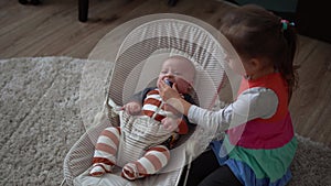 Childhood, motherhood, family, comfort. Little newborn baby boy in striped bodysuit pajamas awake looking around smiles