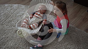 Childhood, motherhood, family, comfort. Little newborn baby boy in striped bodysuit pajamas awake looking around smiles