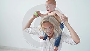 Childhood, motherhood and family concept - Happy mother holds her baby on white background