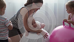 Childhood, Motherhood, games, upbringing, development concept - young mom do exercise, masah with newborn baby on