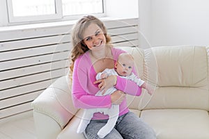 Childhood, motherhood, infant concept - happy mother holding her baby