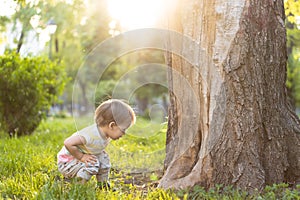 Childhood, nature, summer, parks and outdoors concept - portrait of cute blond-haired little boy in striped multi