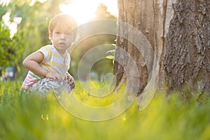 Childhood, nature, summer, parks and outdoors concept - portrait of cute blond-haired little boy in striped multi