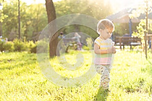 Childhood, nature, summer, parks and outdoors concept - portrait of cute blond-haired little boy in striped multi