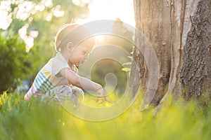 Childhood, nature, summer, parks and outdoors concept - portrait of cute blond-haired little boy in striped multi