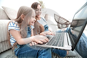 Happy mother with adorable little girl with laptop