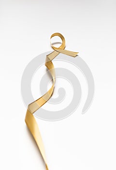 childhood ribbon, gold ribbon as symbol of childhood cancer awareness isolated on white background