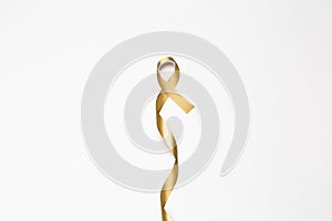 childhood ribbon, gold ribbon as symbol of childhood cancer awareness isolated on white background