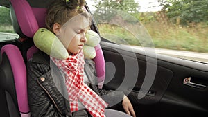 Childhood road trip and people concept - teen girl sleeping in baby car seat with travel pillow