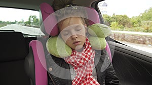 Childhood road trip and people concept - teen girl sleeping in baby car seat with travel pillow