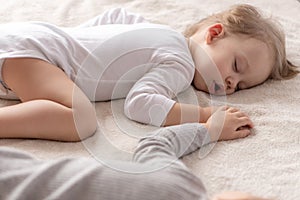 Childhood, sleep, relaxation, family, lifestyle concept - two young children 2 and 3 years old dressed in white and