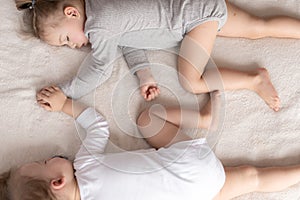 Childhood, sleep, relaxation, family, lifestyle concept - two young children 2 and 3 years old dressed in white and