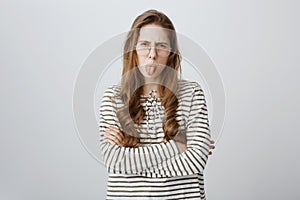 Childish girl expresses her dislike, being impolite and rude. Portrait of attractive displeased daughter in transparent