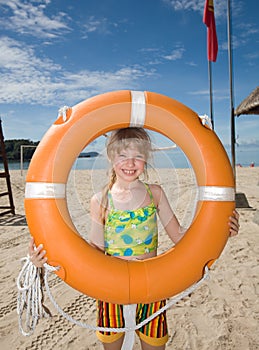 Childl with life buoy at coast.