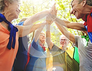 Childlike seniors superheroes giving a high five