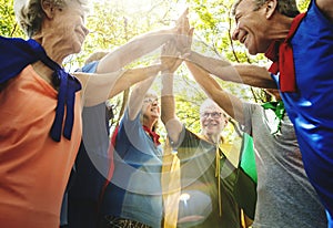 Childlike seniors superheroes giving a high five