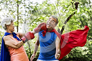 Childlike seniors wearing superhero costumes photo