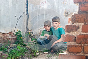 Children in an abandoned house, two poor abandoned boys, orphans as a result of natural disasters and military actions. Submission