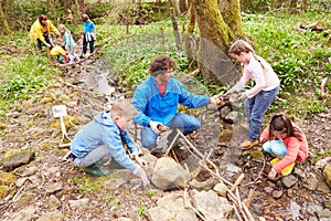 Children And Adults Carrying Out Conservation Work On Stream