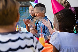 Children applauding while sitting at table