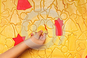 Children bake cookies for Christmas. Raw dough, star shape, tree, bell, heart, on a red background. Top view